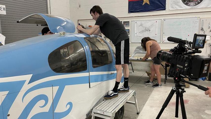 学生们正在安装飞机的门.